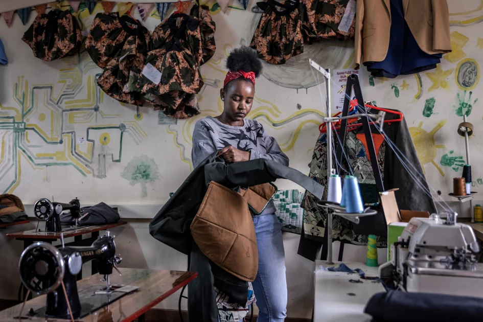 Fashion designer Hellen Wanjiru works on one of her designs at a sewing workshop in Nairobi, on September 25, 2023, ahead of the Kibera Fashion Week. (Photo by LUIS TATO / AFP)