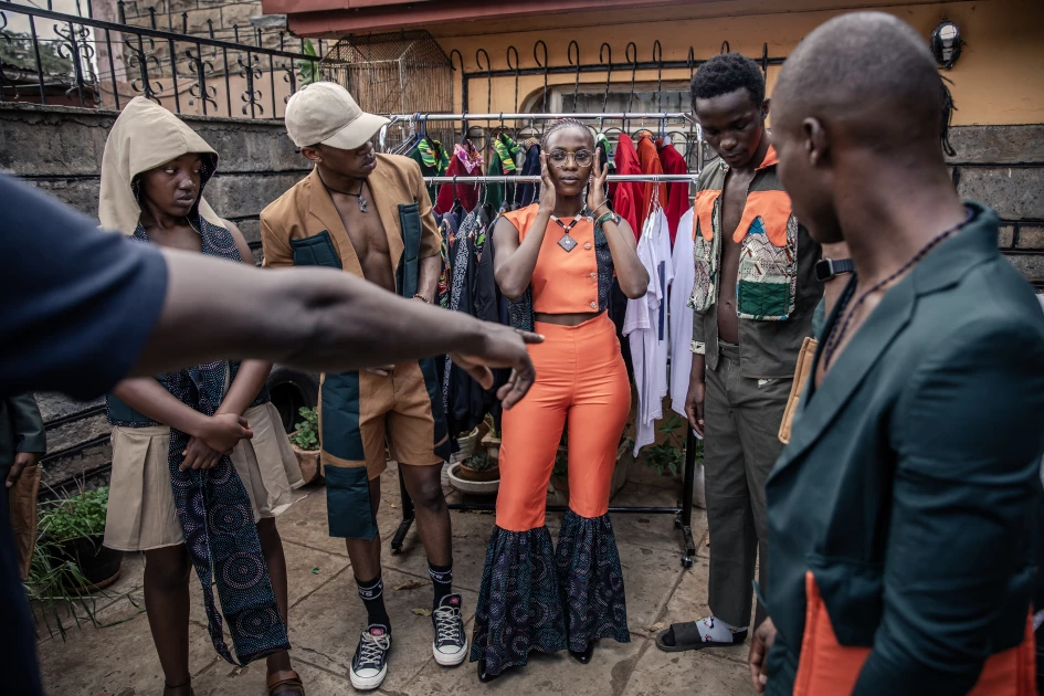 Fashion models gather as they listen to the indications given by a fashion designer during a fitting session at a fashion studio in Kibera in Nairobi, on September 20, 2023, ahead of the Kibera Fashion Week. (Photo by LUIS TATO / AFP)