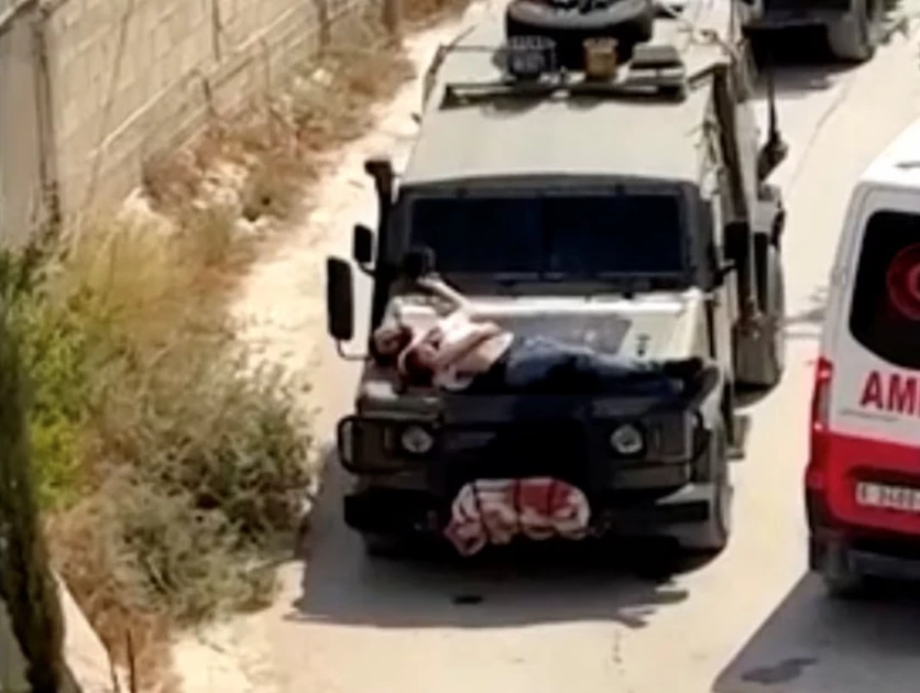 Israeli forces strap wounded Palestinian to jeep during raid